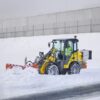 Pala cargadora compacta Wacker Neuson WL250 trabajando en retirada de nieve en exteriores.
